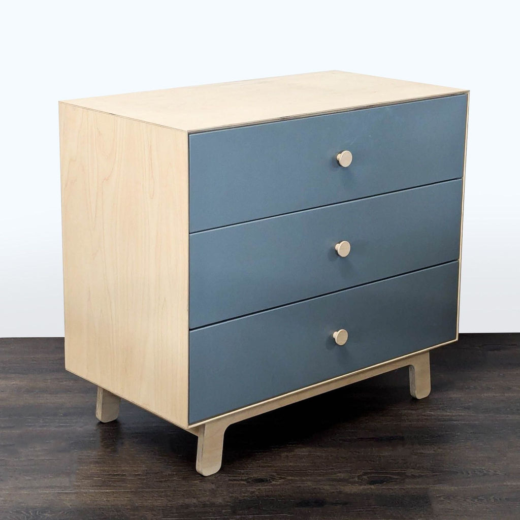 Ouef brand dresser with clean lines, blue drawers, natural wood finish, and ample storage space.