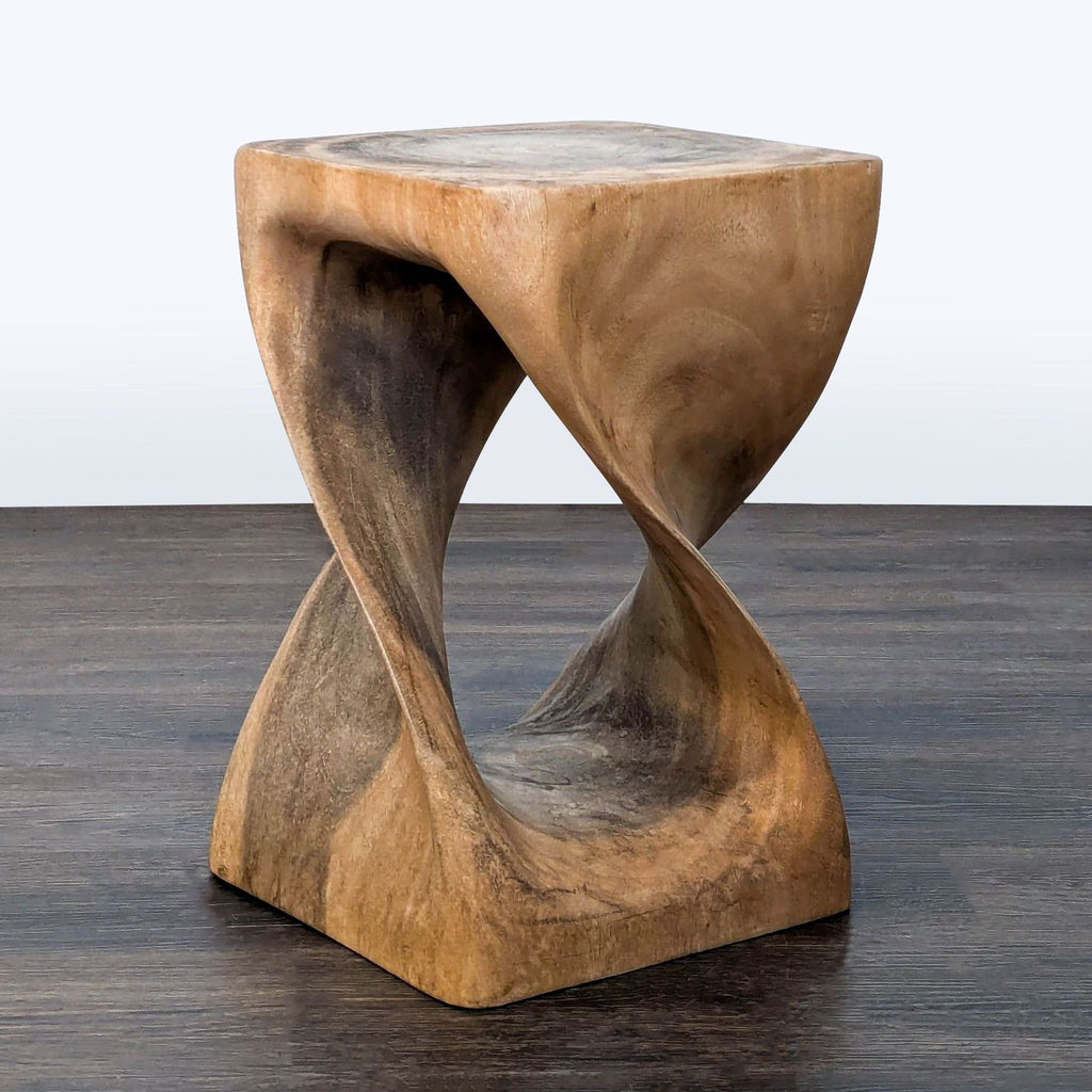 1. Sculptural wooden end table by West Elm with a twisted geometric design, shown on a dark floor.  