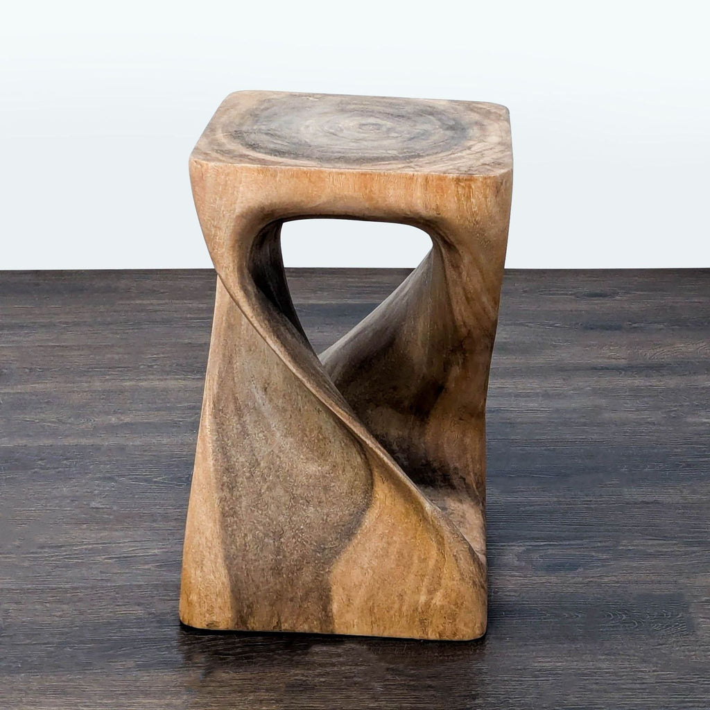 3. Modern West Elm wooden end table with a hollow center and swirling carved appearance on woodgrain.