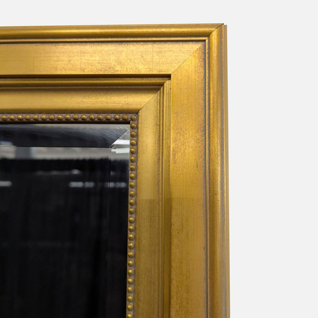 3. Rectangular gold-framed floor mirror leaning against a wall, reflecting light.