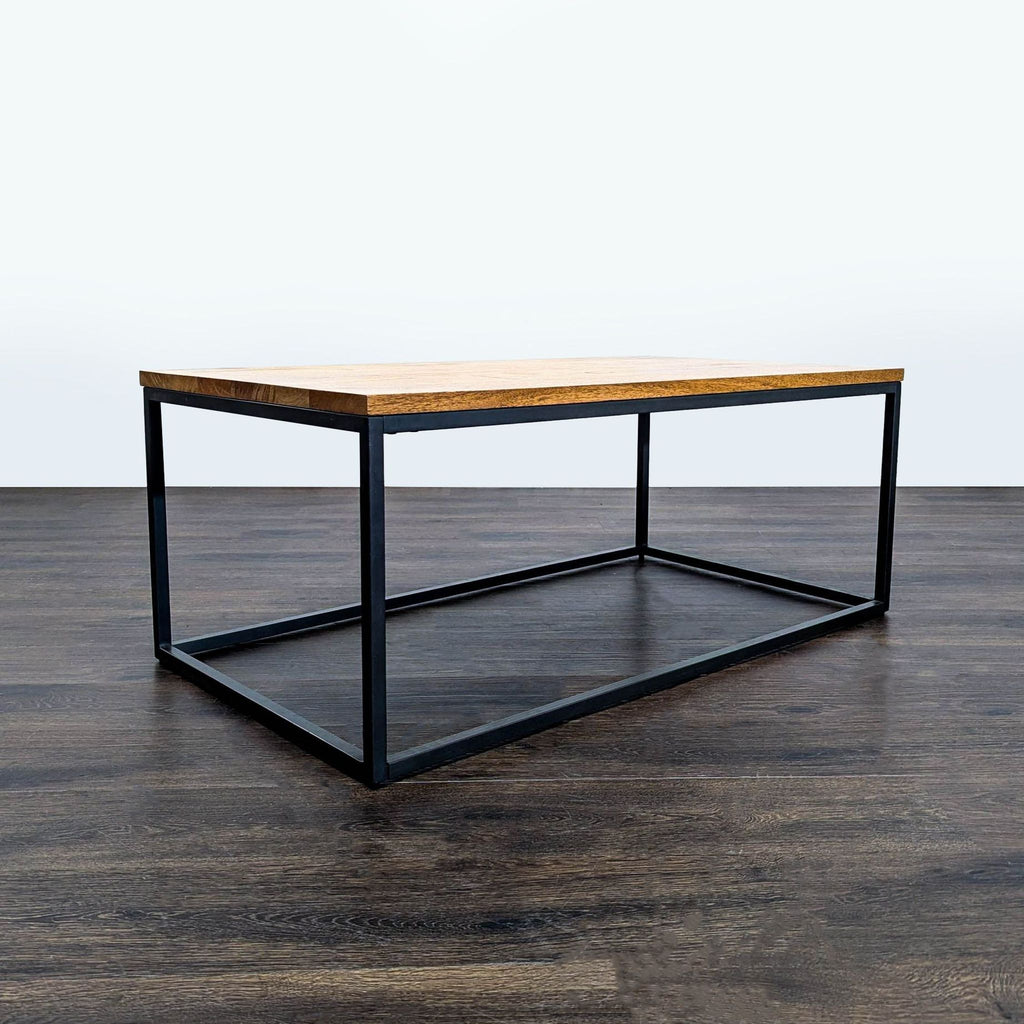 2. West Elm industrial-style coffee table featuring a rectangular wood top and minimalist black steel frame base.  