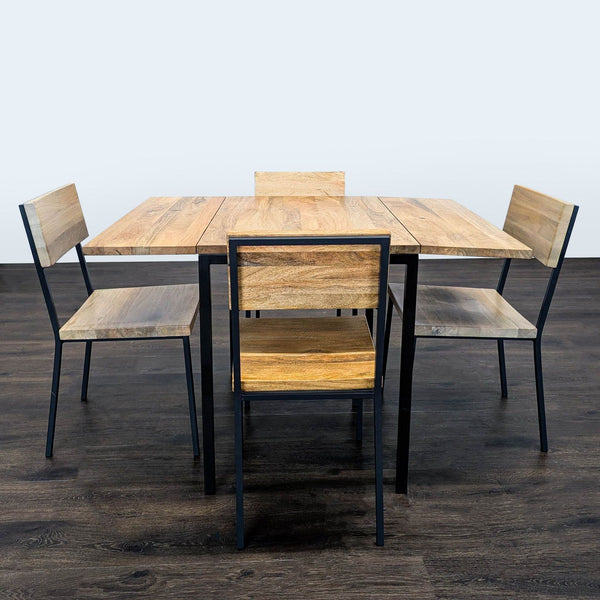 West Elm dining set with wood drop-leaf table and four matching chairs, sleek black metal legs.