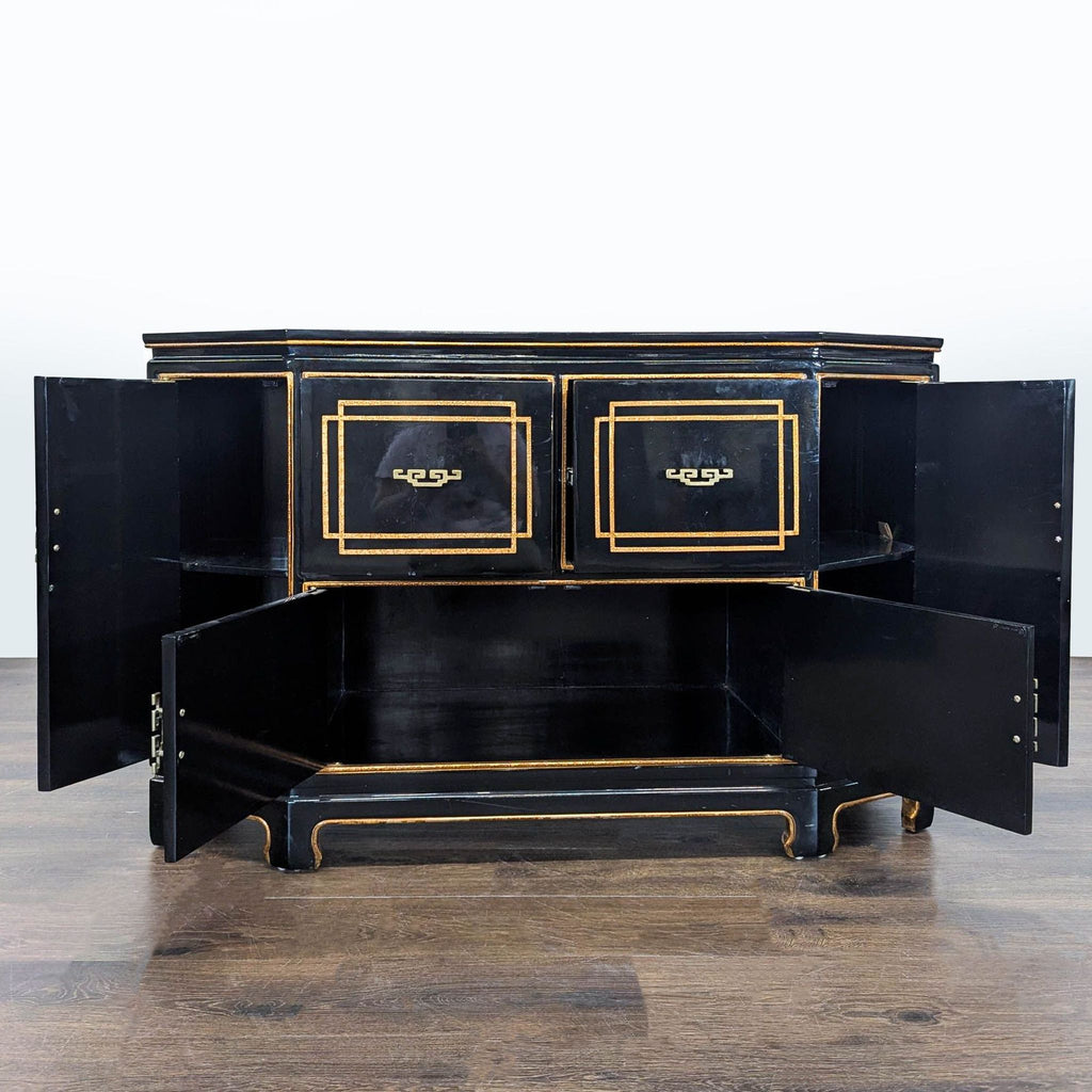 Hollywood Regency black and gold cabinet with ornate trim, featuring multiple doors, shelving, and drawer space.