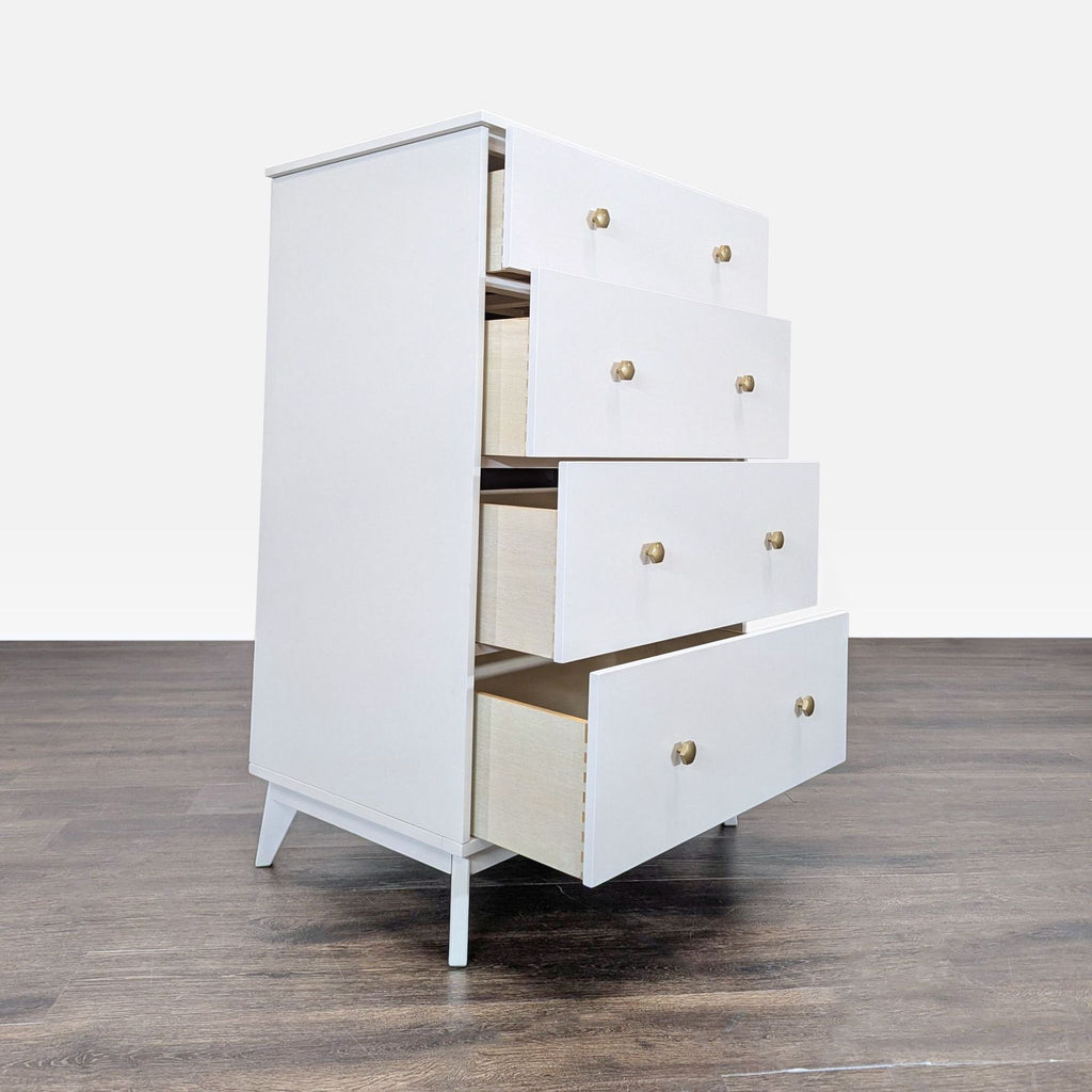 Side angle of a Pottery Barn Teen dresser with all four spacious white drawers partially opened.