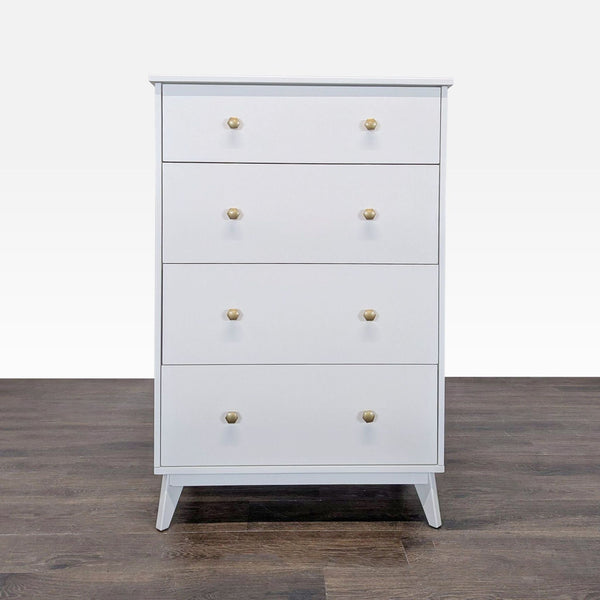 Front view of a Pottery Barn Teen white dresser with four drawers and gold knobs on a wood floor.