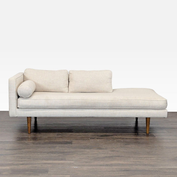 Modern West Elm chaise sofa with beige fabric, wooden legs, and plush cushions for stylish comfort.