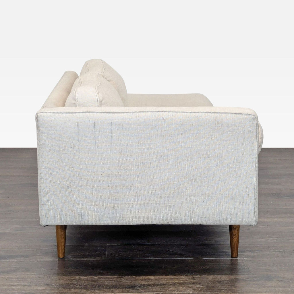 West Elm sofa with chaise lounge, warm wood legs, and elegant upholstery, ideal for cozy spaces.