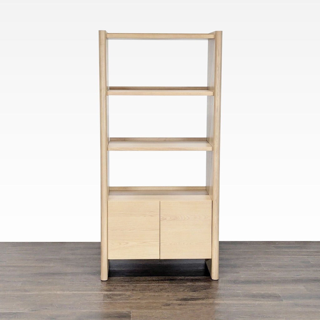 A modern light wood bookshelf from Article with three open shelves and a closed two-door cabinet below.