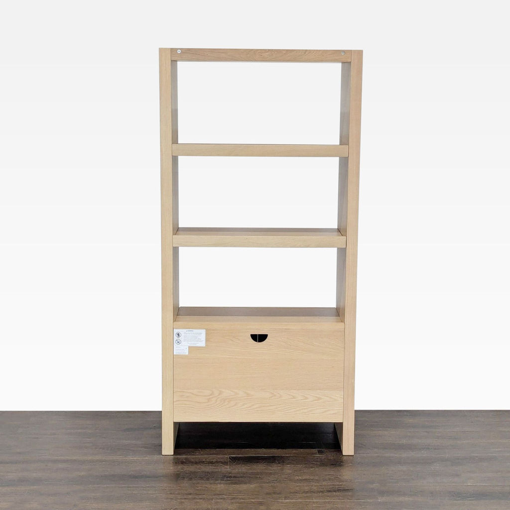 Rear view of a light wood Article bookshelf, showing three open shelves and a closed storage cabinet at the bottom.
