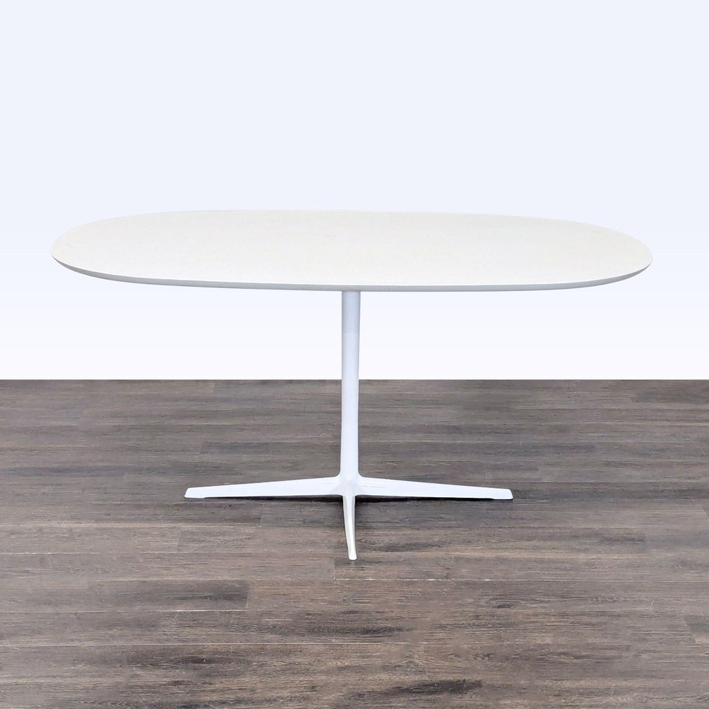White Eames Dining Set features pedestal-base table and four molded seat chairs with metal legs for stability.
