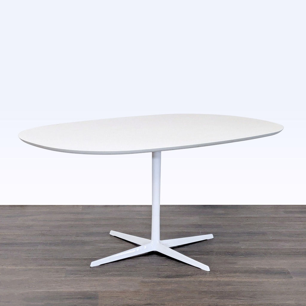 Modern Eames Dining Set: oval white table with pedestal base and four comfortable chairs, perfect for family meals.