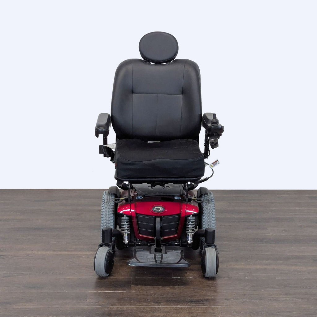 Electric wheelchair by Quantum with comfortable black seat, new battery, charger, and stable outdoor wheels.