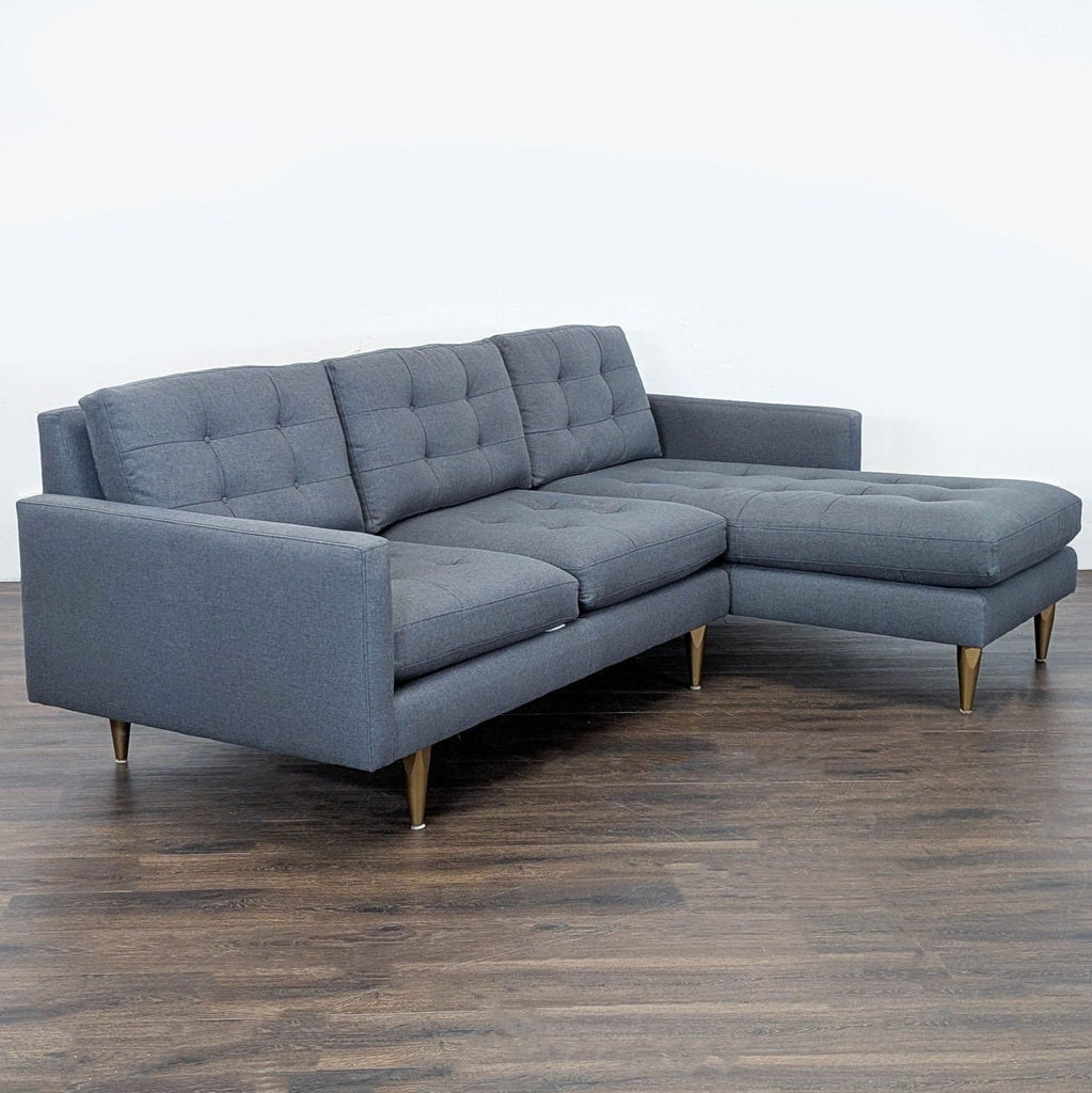 Modern gray sectional sofa by Crate & Barrel features clean lines, tufted seats, and sturdy legs with a chaise lounge.  