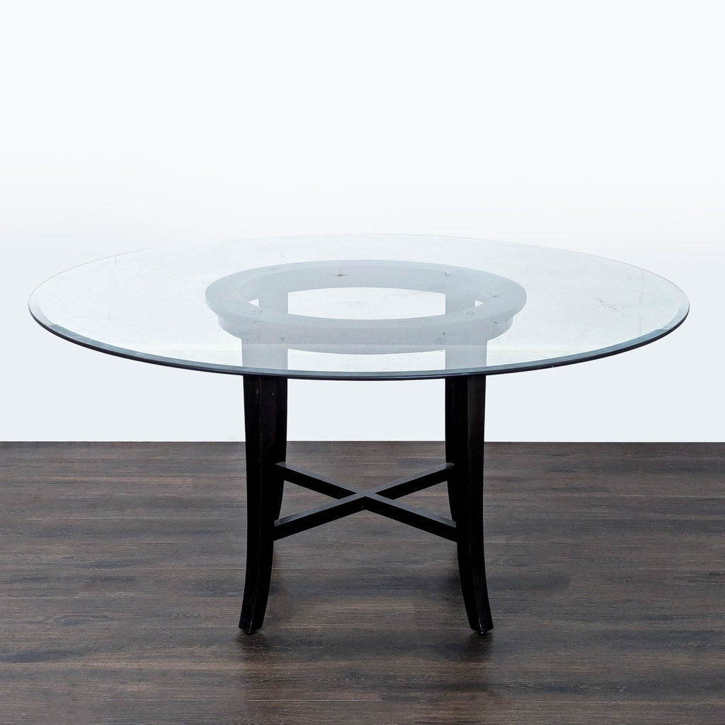 2. Modern dining table featuring a circular glass surface and sturdy, dark-colored base with cross supports.  