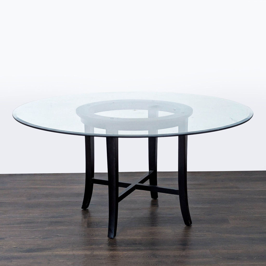 1. Round dining table with a clear glass top and dark wooden legs, displayed on a wood floor.  
