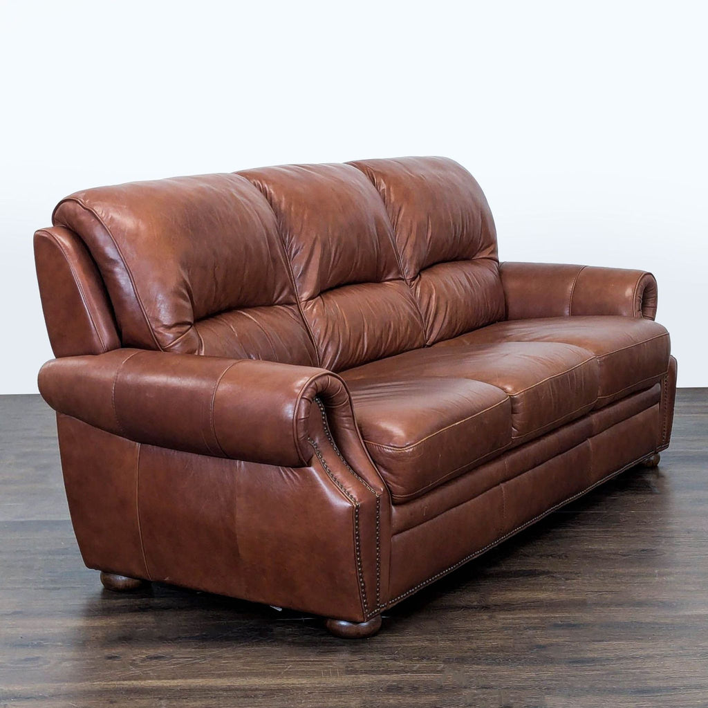 Elegant 3-seater sofa upholstered in soft brown leather, featuring nailhead details and supportive cushioning.
