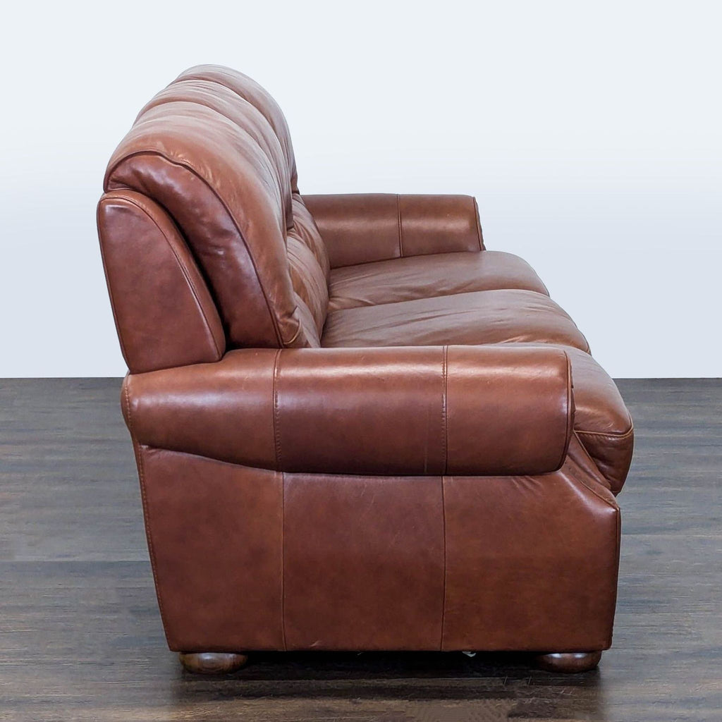 Classic brown leather 3-seat sofa with rolled arms, decorative trim, and comfortable, durable construction.