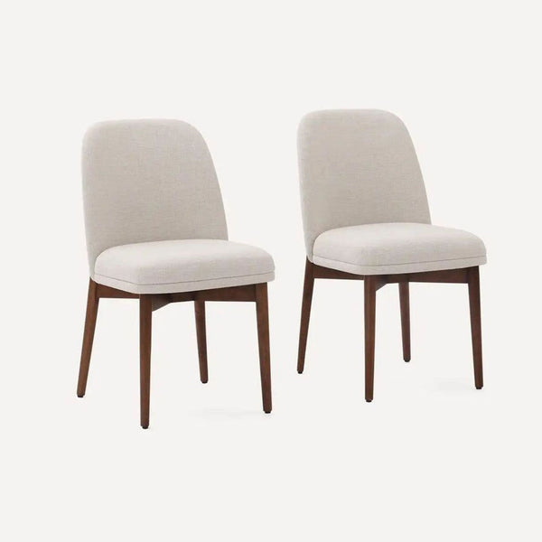 Set of upholstered dining chairs with wooden legs by Burrow Furniture, shown arranged in a dining setting.