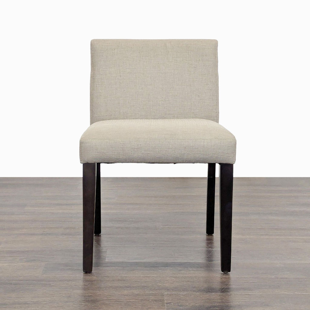 1. Front view of EQ3 Mid-Century dining chair with beige upholstery and dark wood legs.  
