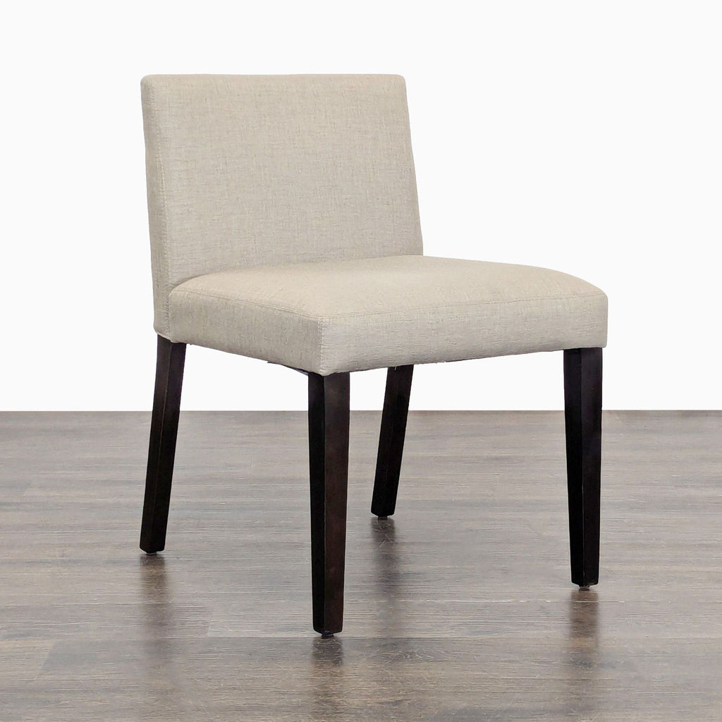 2. Angled view of EQ3 Mid-Century dining chair, showing padded seat and wood legs.  