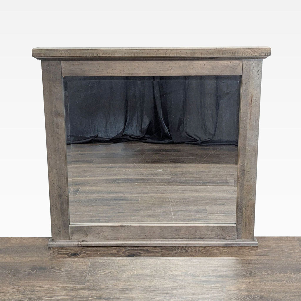 1. Rectangular Vaughan-Bassett mirror with a rustic wood frame in stone grey, reflecting a wood floor and curtain.