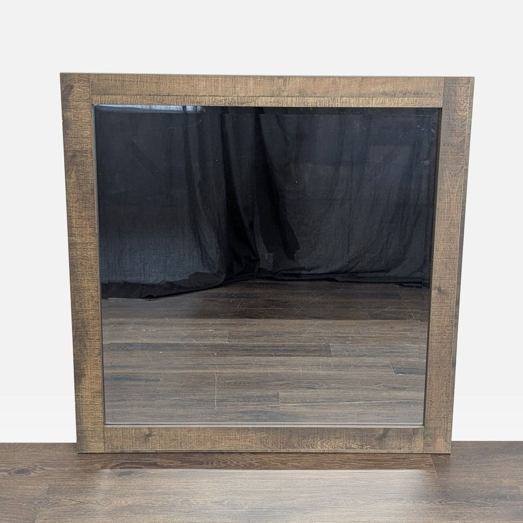 1. Square mirror by Crown Mark with a rustic wooden frame, reflecting wood flooring and a black backdrop.