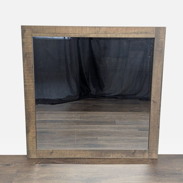 1. Square mirror by Crown Mark with a rustic wooden frame, reflecting wood flooring and a black backdrop.