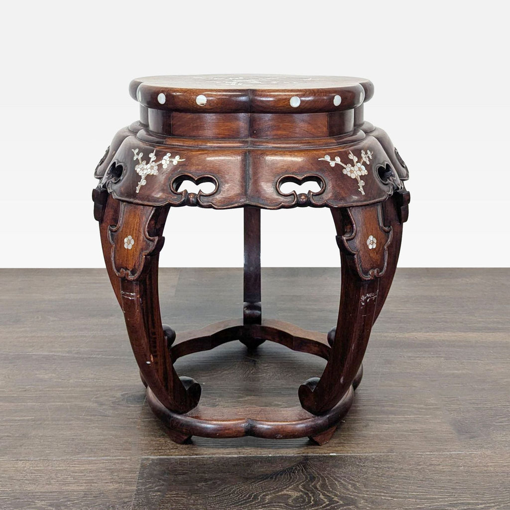 End table featuring a round surface adorned with mother of pearl floral inlay patterns.