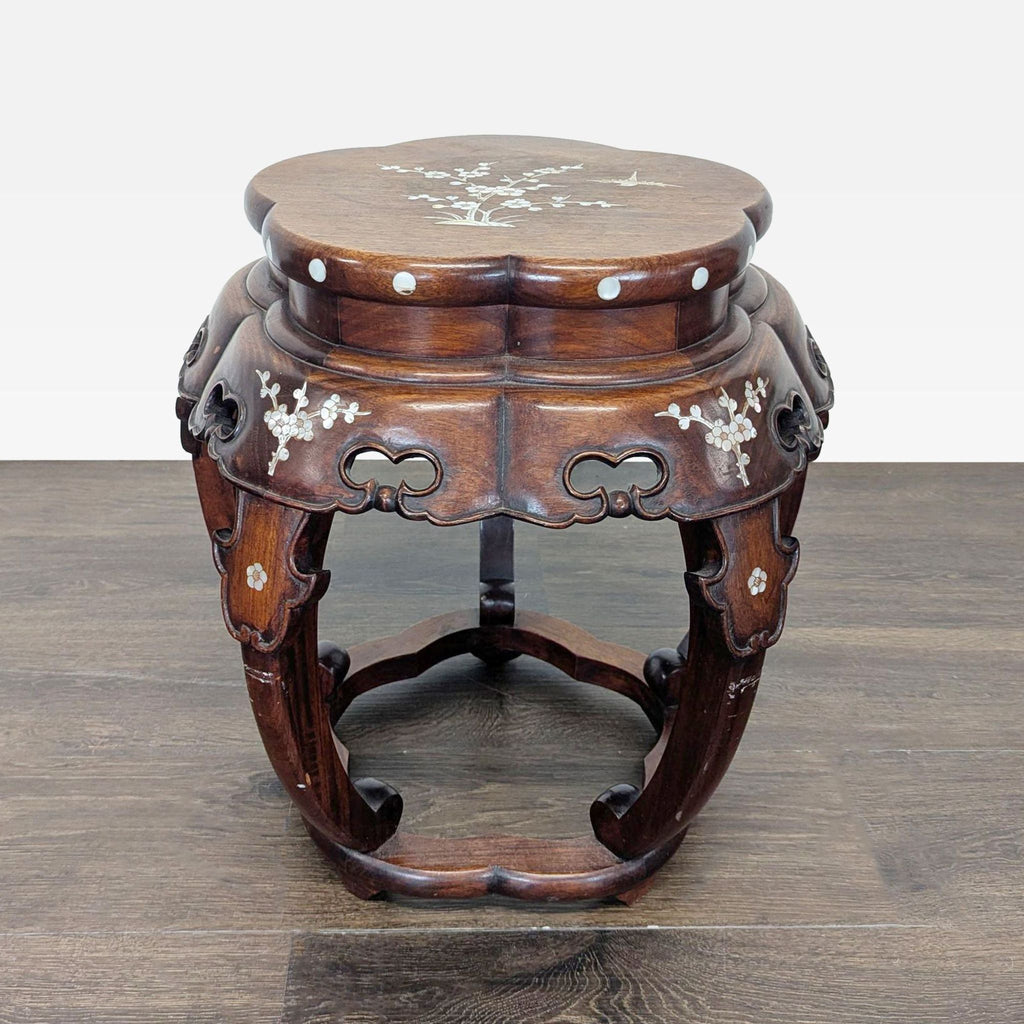 Mother of pearl floral inlay decorates a round end table with elegant, intricate detailing.