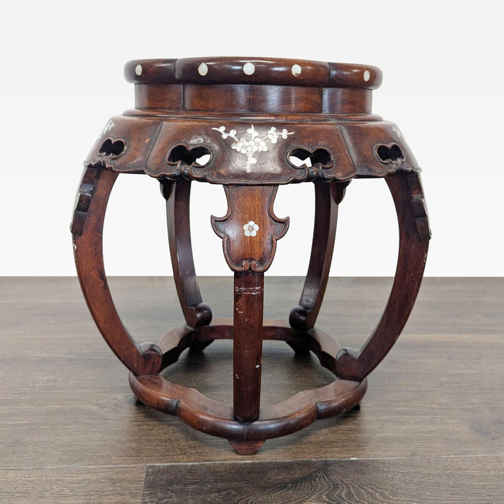 Detailed view of a luxurious end table showcasing mother of pearl inlay arranged in floral motifs.