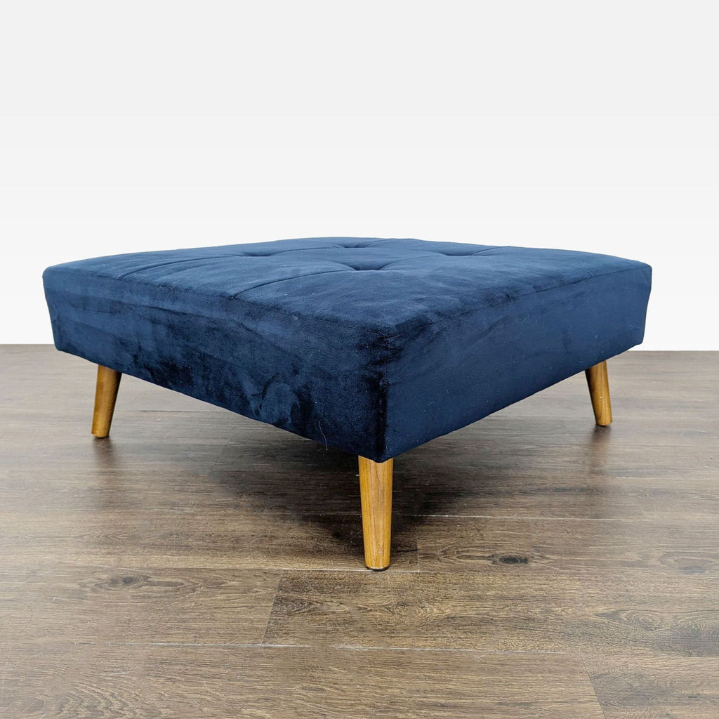 1. Square navy blue ottoman with wooden legs, tufted top, on a wood floor, viewed at an angle.