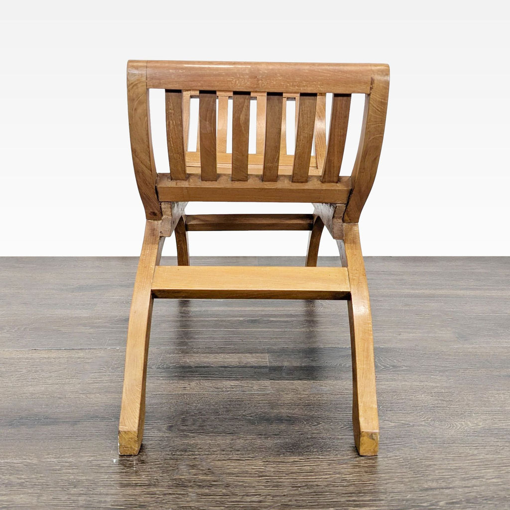 Wooden slatted bench with curved legs, viewed from the front, placed on a dark wooden floor.
