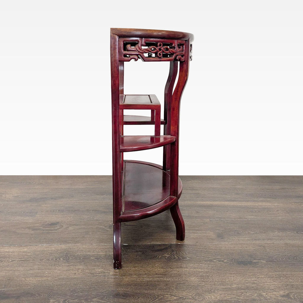 Curved console table featuring three shelves and decorative apron details, perfect for entryways.  