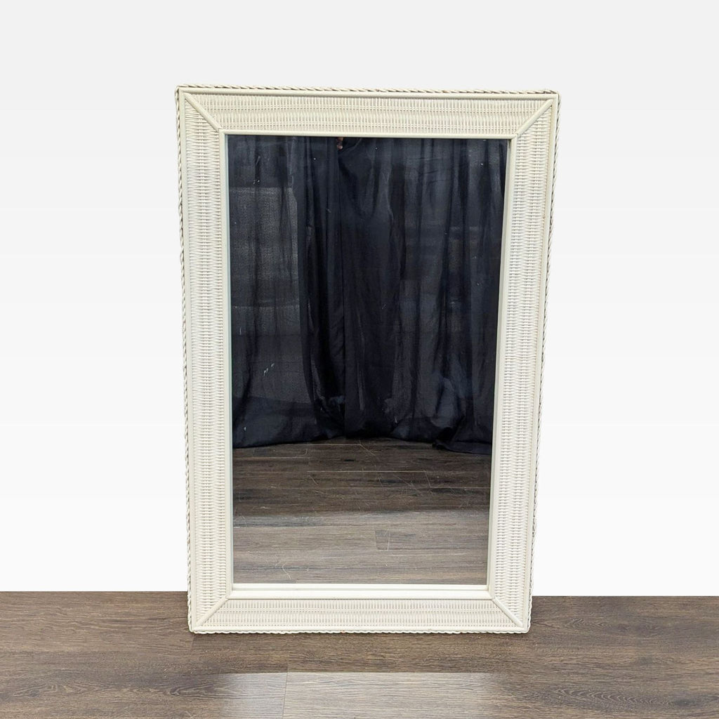 1. Rectangular mirror with a white woven wicker frame, displayed upright on a wooden floor.