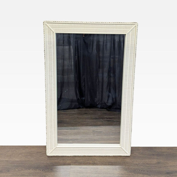 1. Rectangular mirror with a white woven wicker frame, displayed upright on a wooden floor.