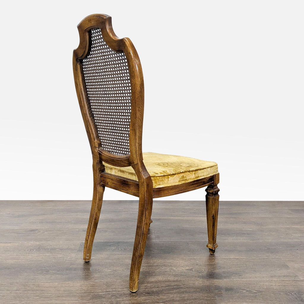 Side view of a Century Furniture dining chair with cane backrest and gold velvet seat on wood legs.