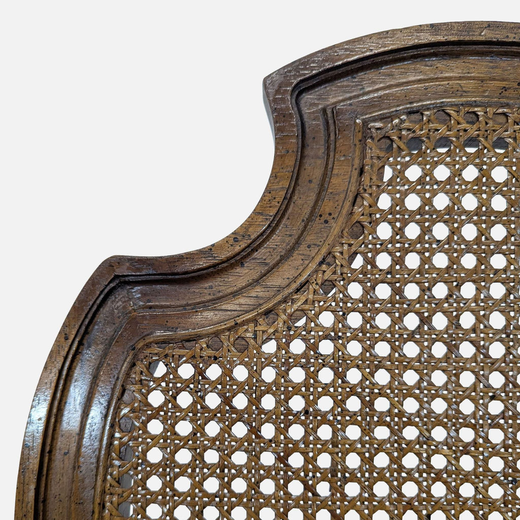 Close-up of a Century Furniture dining chair, showing detailed cane back and carved wood frame.  