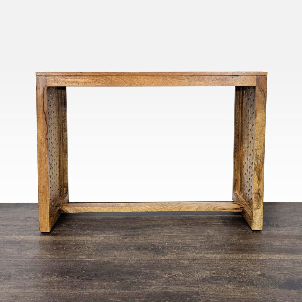 1. Rectangular wooden console table with carved geometric patterns on the sides, shown on a dark floor.  