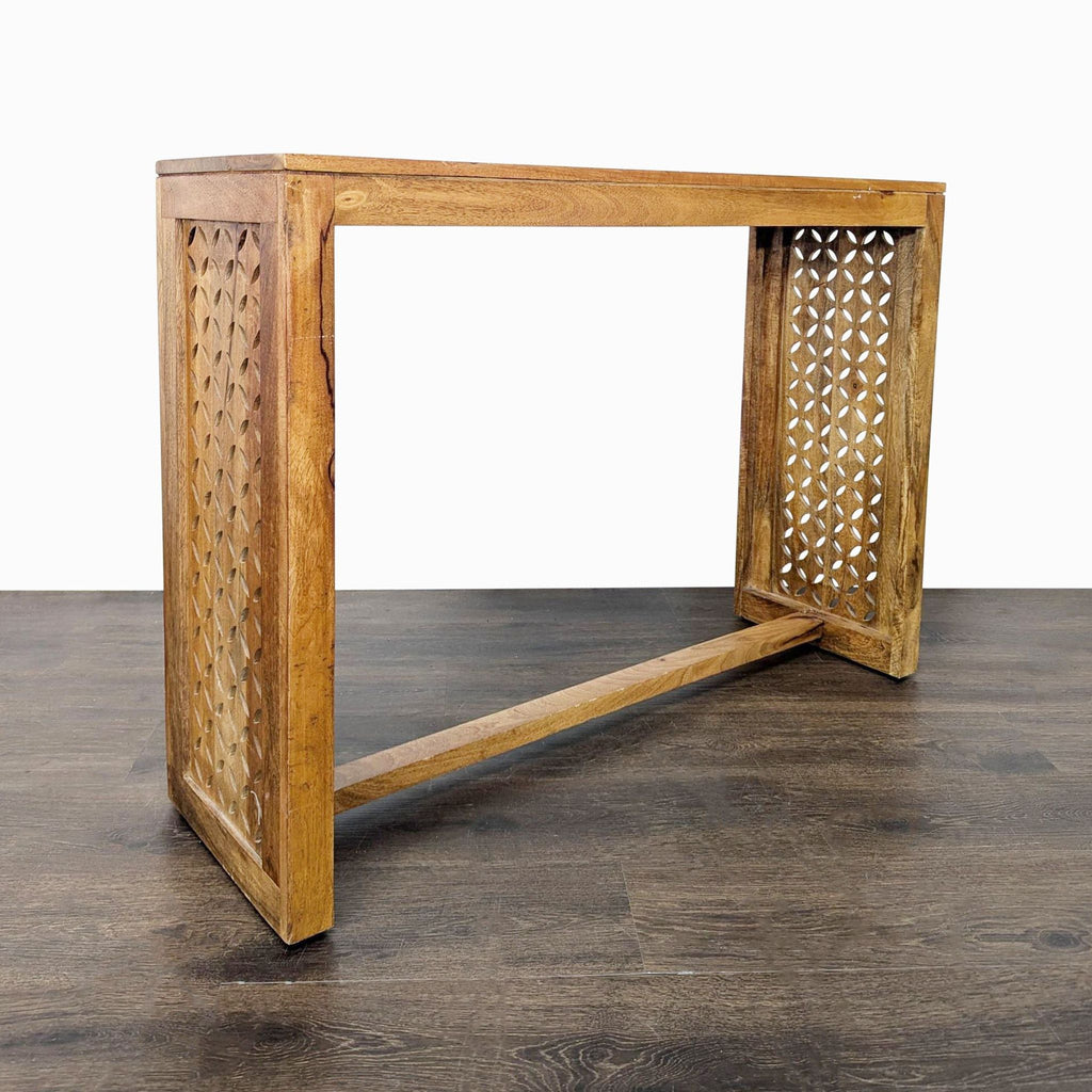 2. Angled view of a wooden side table featuring decorative cutout designs on both side panels.  