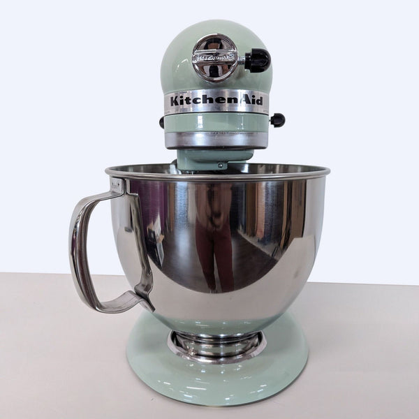 Mint green KitchenAid Artisan stand mixer with large stainless steel bowl and handle on a white background.  