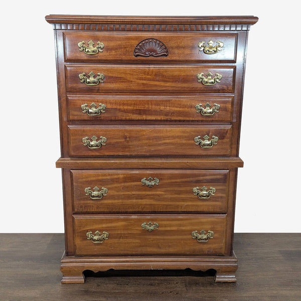 1. Front view of a brown wooden dresser with brass handles, carved detailing, and multiple spacious drawers.