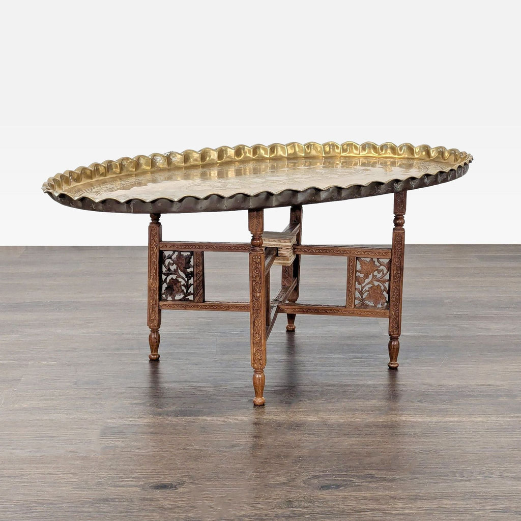 Exquisite brass tray table featuring detailed floral etching and a folding carved stand for easy storage.