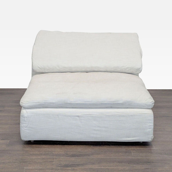 Restoration Hardware armless sectional chair in light linen with plush cushions, offering a modern and cozy seating option.