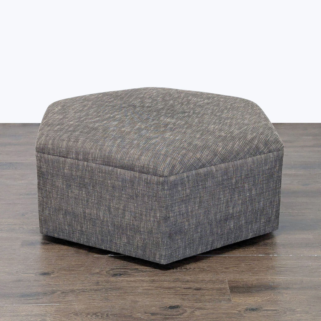 1. Hexagonal gray fabric ottoman with a modern design, displayed on a wooden floor.