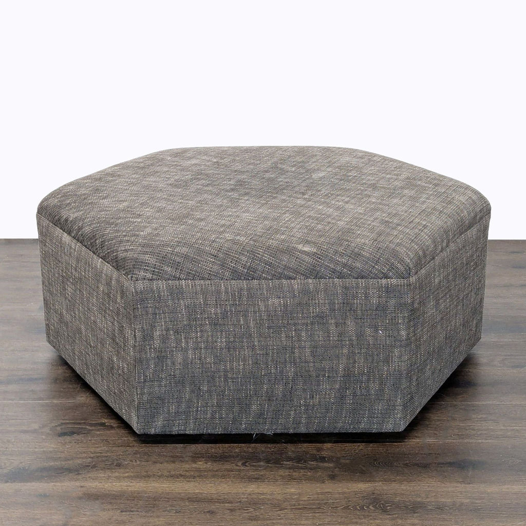 2. Front view of a textured gray ottoman with a soft, geometric shape for seating or decor.