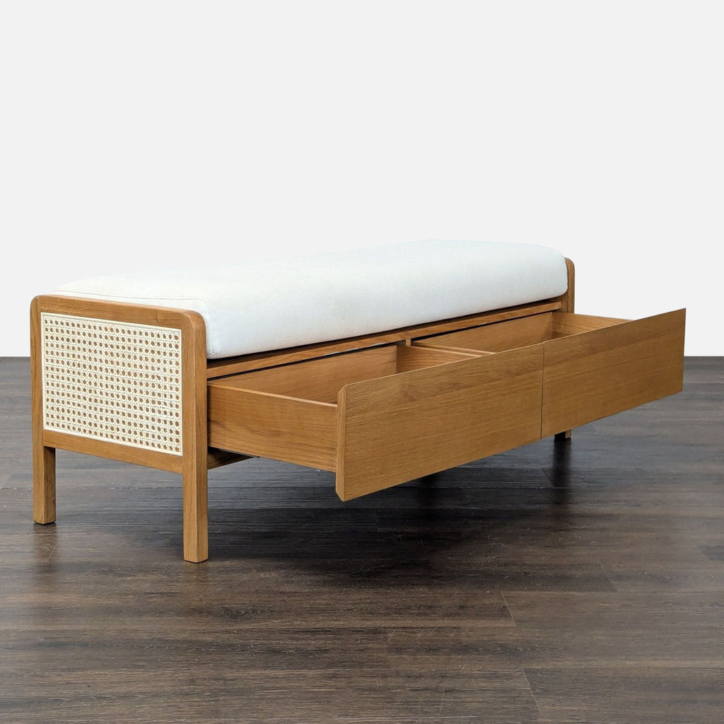 2. Side view of a wooden bench by Article with cane panel sides and open drawer storage beneath the seat.