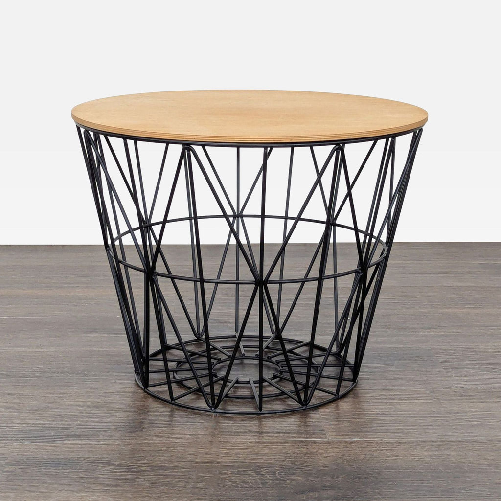 1. Modern Ferm Living end table with a round wood top and black geometric metal wire base on dark wood floor.