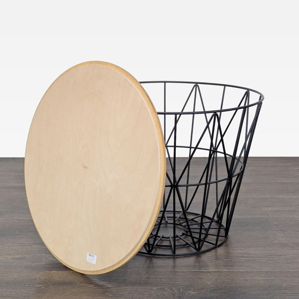 2. Detachable round wooden top next to a black wire basket base, highlighting the Ferm Living end table design.