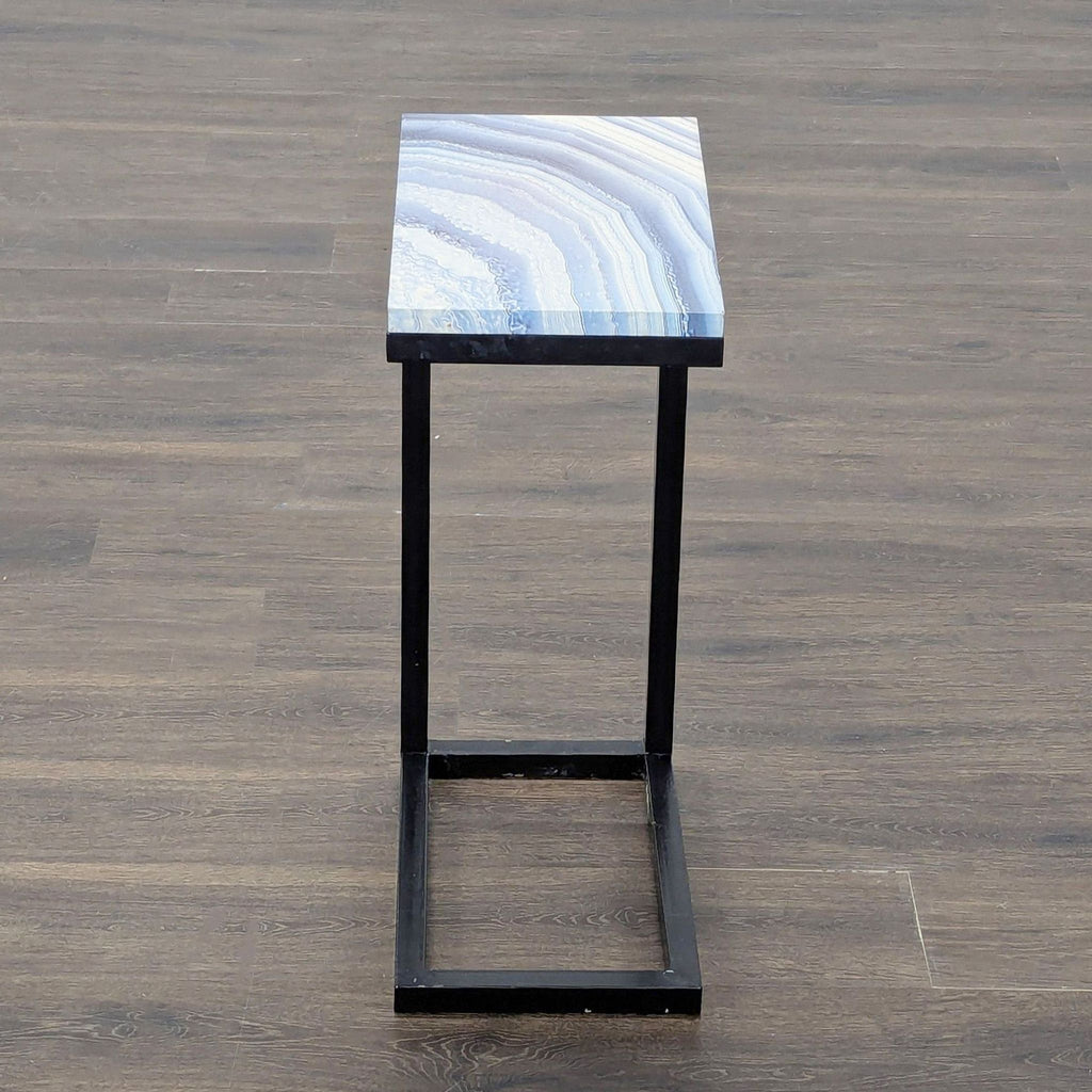 2. Small console table featuring a glossy blue patterned surface and minimalist black metal base.