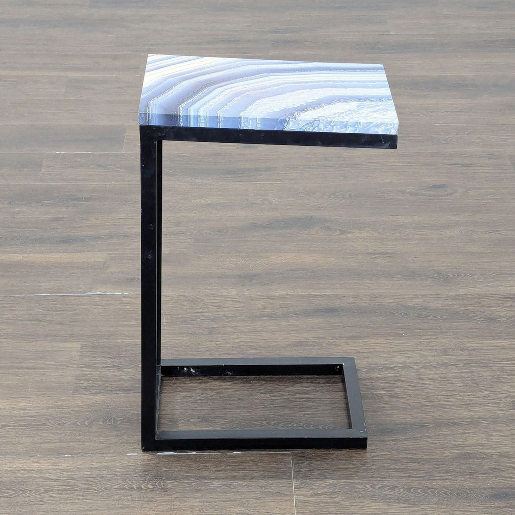 3. Contemporary side table with geometric black metal frame and shiny blue stone-like tabletop.